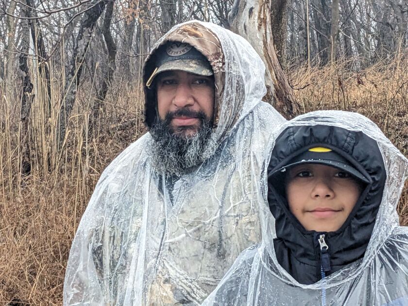 Vicente Valadez and his son George in their raincoats in the rain, snow and sleet Saturday morning on a trout open day at Green Lake in Calumet City.  Credit: Dale Bowman