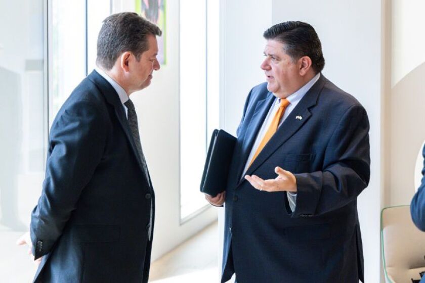 Governor JB Pritzker (right) talks with Rowan Adams, executive vice president of Tate & Lyle, a global food and beverage supplier, on Tuesday,
